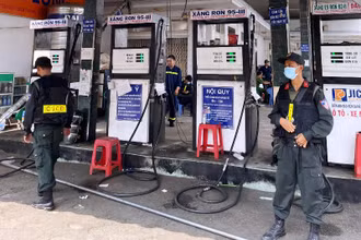 Cảnh sát cơ động bảo vệ hiện trường việc khám xét cây xăng doanh nghiệp tư nhân xăng dầu Bình Long.