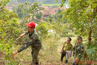 Kiểm lâm viên địa bàn cùng Trưởng bản Vì Văn Khiên kiểm tra công tác chăm sóc rừng trên khu rừng của bản Mường Pồn 1.