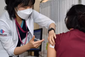 Một nhân viên y tế nhận được liều đầu tiên của vaccine ngừa Covid-19 của Pfizer - BioNTech tại trung tâm tiêm chủng của Trung tâm Y tế Quốc gia ở Seoul, Hàn Quốc ngày 27-2. Ảnh: Reuters.