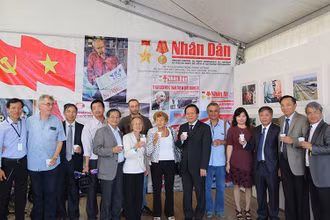 Tác giả (thứ năm từ trái sang) và một số Việt kiều vinh dự chụp ảnh cùng Đoàn đại biểu Báo Nhân Dân do Phó Tổng Biên tập Phan Huy Hiền dẫn đầu và các bạn Pháp gắn bó với Việt Nam tại Gian trưng bày Báo Nhân Dân ở Hội báo Nhân đạo tháng 9-2016. 