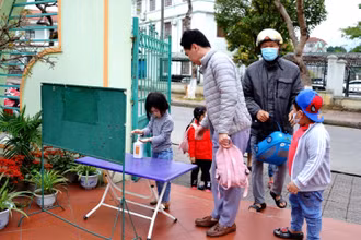 Học sinh Trường mầm non Hoa Đào thực hiện sát khuẩn tay và đeo khẩu trang trước khi vào lớp học.