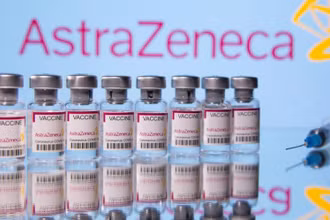 Các lọ vaccine ngừa Covid-19 của Astra Zeneca trước logo của nahf sản xuất được chụp vào ngày 14-3. Ảnh: Reuters.