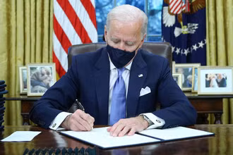 Tổng thống Mỹ Joe Biden ký các sắc lệnh tại phòng Bầu Dục của Nhà Trắng, ở Washington, Mỹ, sau khi ông tuyên thệ nhậm chức ngày 20-1-2021. (Ảnh: Reuters)