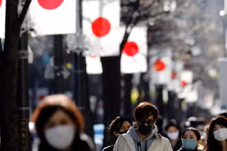 Người Nhật Bản ở Tokyo đi bộ đeo khẩu trang bảo vệ trong bối cảnh dịch Covid-19 bùng phát ngày 10-1. Ảnh: Reuters.