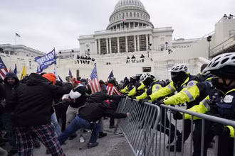 Người biểu tình ủng hộ ông Trump tìm cách phá vỡ rào chắn của cảnh sát để xông vào tòa Quốc hội, ngày 6-1. (Ảnh: AP)