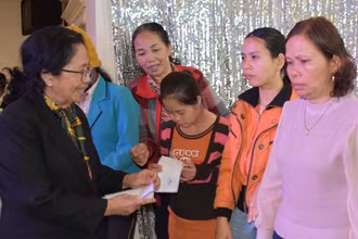 Giáo sư, bác sĩ Nguyễn Thị Ngọc Phượng, Phó Chủ tịch Trung ương Hội nạn nhân chất độc da cam/dioxin Việt Nam tặng quà cho các gia đình. Ảnh: Hà Phương