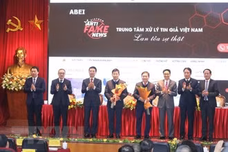 Phó Thủ tướng Vũ Đức Đam và Bộ trưởng Bộ Thông tin và Truyền thông Nguyễn Mạnh Hùng tặng hoa chúc mừng Khai trương Cổng thông tin tiếp nhận phản ánh và công bố tin giả và ra mắt đầu số tiếp nhận phản ánh tin giả 18008108. Ảnh: TTXVN.