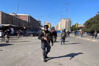 Lực lượng an ninh Iraq bảo vệ hiện trường vụ tấn công liều chết tại Baghdad, ngày 21-1. (Ảnh: Reuters)
