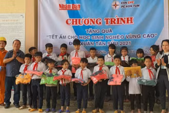 Phóng viên Báo Nhân Dân cùng đại diện Công ty Điện lực Kon Tum trao áo ấm cho các em học sinh Trường PTDT bán trú tiểu học Đắk Nên.
