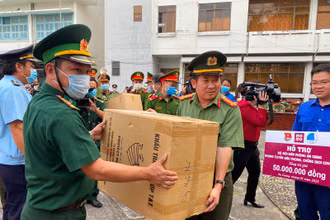 Đại tá Đinh Văn Nơi (trái) trao tặng khẩu trang y tế cho các chiến sĩ tham gia phòng, chống dịch trên tuyến biên giới.