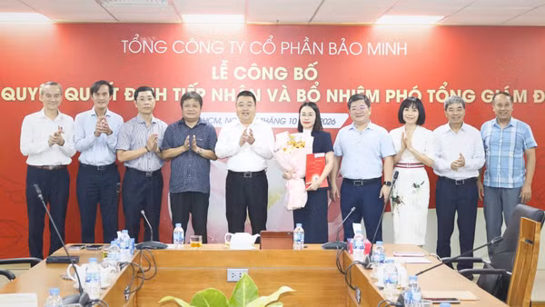 Bà Phạm Thị Kim Anh nhận quyết định bổ nhiệm và hoa chúc mừng từ Ban Lãnh đạo Bảo Minh. (Ảnh: MINH NGUYỄN)