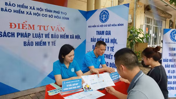 Cán bộ cơ quan Bảo hiểm xã hội cơ sở Hòa Bình (Phú Thọ) tư vấn chính sách bảo hiểm xã hội, bảo hiểm y tế cho người dân. (Ảnh: nhandan.vn)