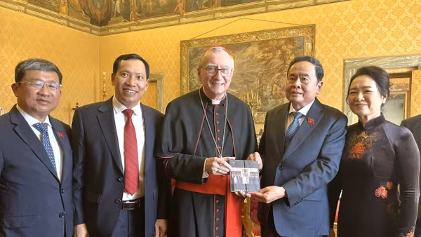 Chủ tịch Quốc hội Trần Thanh Mẫn và Phu nhân chụp ảnh chung với Thủ tướng Tòa thánh Vatican, Hồng y Pietro Parolin và trao đổi tặng phẩm. (Ảnh: TTXVN)