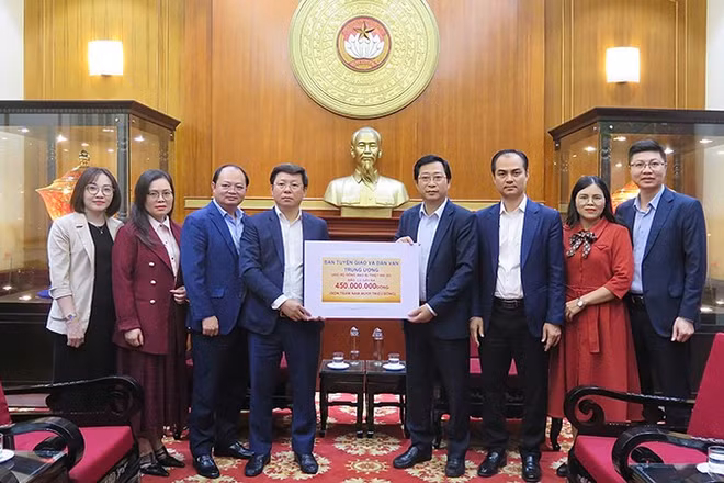 Đại diện lãnh đạo, cán bộ Ban Tuyên giáo và Dân vận Trung ương trao biển tượng trưng số tiền ủng hộ đồng bào vùng lũ tại trụ sở Ủy ban Trung ương Mặt trận Tổ quốc Việt Nam.