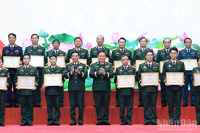 Các đồng chí Phan Văn Giang, Nguyễn Trọng Nghĩa (lần lượt thứ 4 và 5 từ trái sang, hàng đầu) trao Bằng khen tặng những tác giả, đại diện nhóm tác giả tiêu biểu giành Giải thưởng "Tuổi trẻ sáng tạo trong quân đội" lần thứ 26. (Ảnh: MAI TÙNG)
