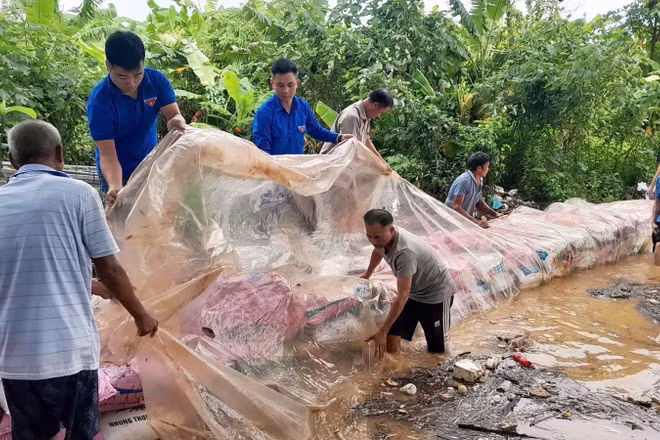 Đoàn viên, thanh niên tình nguyện hỗ trợ bà con đắp bờ chắn dòng chảy tại xã Nam Phù (Hà Nội).