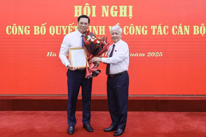 Đồng chí Đỗ Văn Chiến (bên phải) tặng hoa chúc mừng đồng chí Bùi Duy Đông.