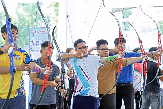 Thanh niên công nhân tranh tài bắn cung tại ngày hội.