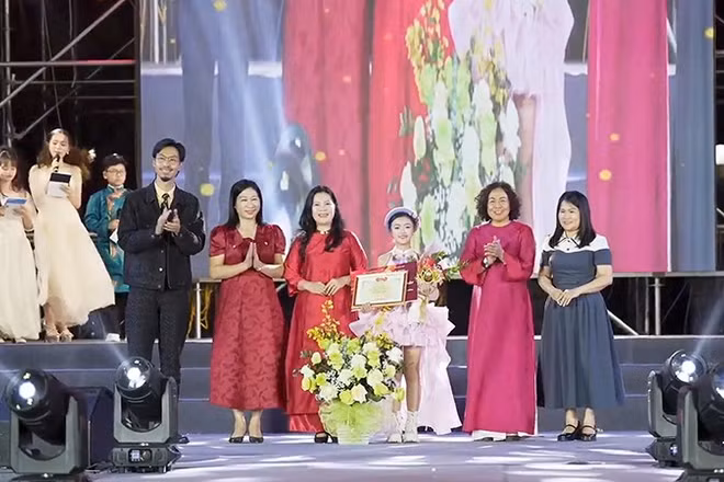 Đại diện Ban tổ chức và rapper Đen trao phần thưởng tặng thí sinh Lê Ngọc Minh Giang.
