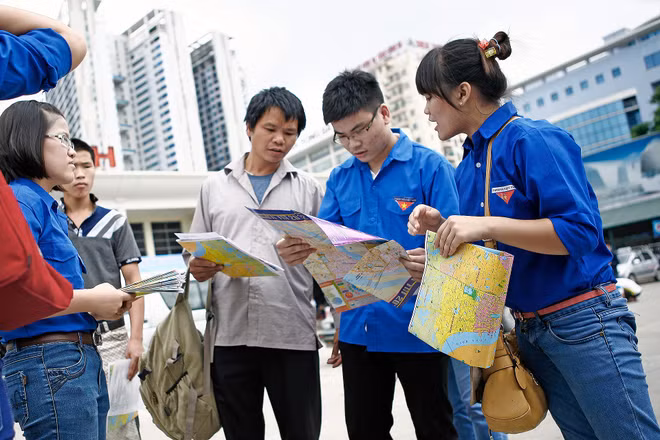 Những tình nguyện viên "đời đầu" của chương trình "Tiếp sức mùa thi" hỗ trợ, hướng dẫn thí sinh thi đại học tìm đường bằng bản đồ.