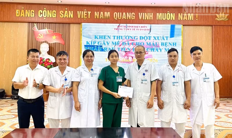 Lãnh đạo Trung tâm Y tế Tuần Giáo trao thưởng, động viên thành viên kíp trực đã phẫu thuật, cấp cứu và hiến máu cứu bệnh nhân qua cơn nguy kịch. (Ảnh: LÊ LAN)