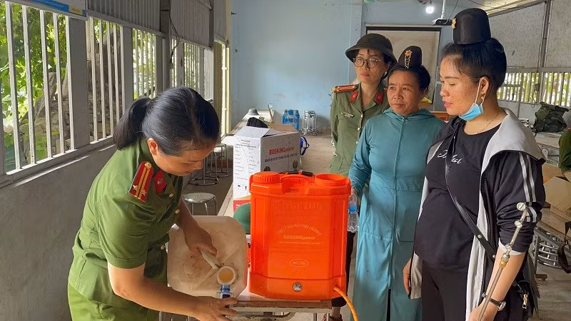 Hội viên phụ nữ Công an tỉnh Điện Biên hướng dẫn người dân cách khử khuẩn bằng chế phẩm sinh học. 