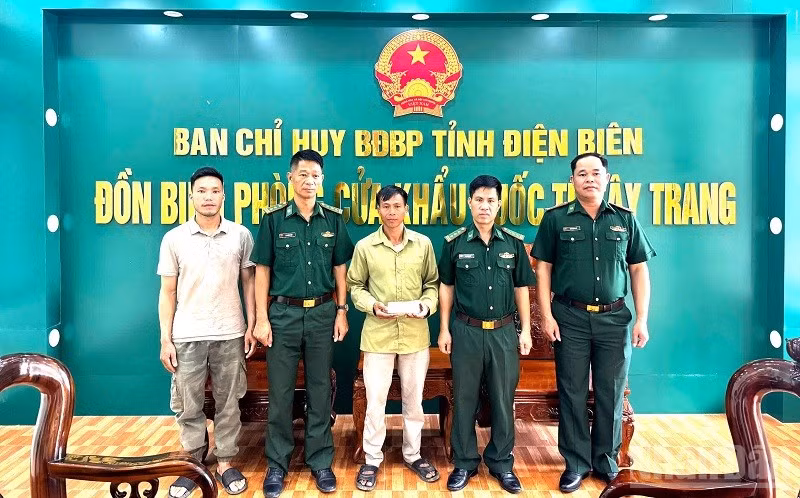 Đại diện lãnh đạo Đồn Biên phòng Cửa khẩu quốc tế Tây Trang chứng kiến Thiếu tá Nông Văn Thiết (người đầu tiên bên phải) trả lại tiền cho người đánh rơi. (Ảnh: LÊ LAN)