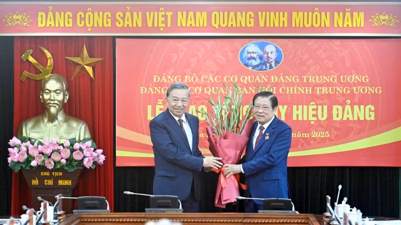 Tổng Bí thư Tô Lâm trân trọng trao Huy hiệu 45 năm tuổi đảng và chúc mừng đồng chí Phan Đình Trạc. (Ảnh: ĐĂNG KHOA)