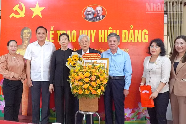 Bí thư Tỉnh ủy Đồng Tháp Ngô Chí Cường (thứ 3 từ phải qua) trao Huy hiệu Đảng và tặng hoa chúc mừng đồng chí Huỳnh Minh Đoàn. (Ảnh: Hữu Nghĩa)