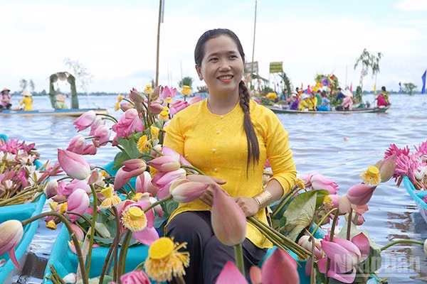 Duyên dáng bên chiếc xuồng sen trên cánh đồng mùa nước nổi. (Ảnh: HỮU NGHĨA)