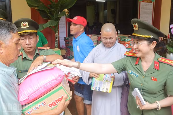Lãnh đạo Phòng Nghiệp vụ Công an tỉnh trao quà tặng người dân. (Ảnh: PHƯỚC THANH)