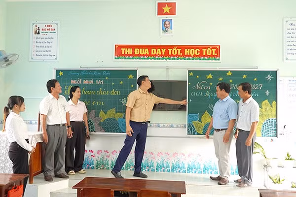 Cán bộ, giáo viên Trường tiểu học Tân Quới và cán bộ Phòng Văn hóa-Thông tin xã Tân Long kiểm tra cơ sở vật chất tại một phòng học của trường. (Ảnh: HỮU NGHĨA)