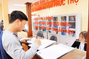 Giải quyết thủ tục hành chính tại Bộ phận một cửa UBND huyện Phúc Thọ. Ảnh: THANH HẢI