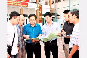 Cán bộ MTTQ phường Yết Kiêu, quận Hà Đông (Hà Nội) trao đổi, giám sát công việc cải tạo một công trình văn hóa. Ảnh: BÁ HOẠT