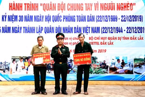 Lãnh đạo Bộ CHQS tỉnh Đắk Lắk trao tặng tiền cho các cựu chiến binh xã Cư Kbang sửa chữa nhà và mua bò giống.