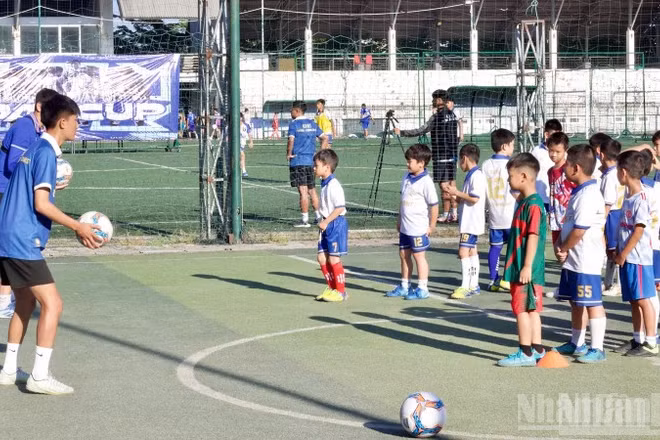 Các cầu thủ nhí học kỹ năng đá bóng cùng huấn luyện viên.