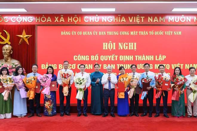 Các đồng chí Đỗ Văn Chiến, Hà Thị Nga (thứ tám và chín từ phải sang) trao Quyết định, tặng hoa chúc mừng người đứng đầu các tổ chức đảng ở các đơn vị trực thuộc Cơ quan Ủy ban Trung ương Mặt trận Tổ quốc Việt Nam.