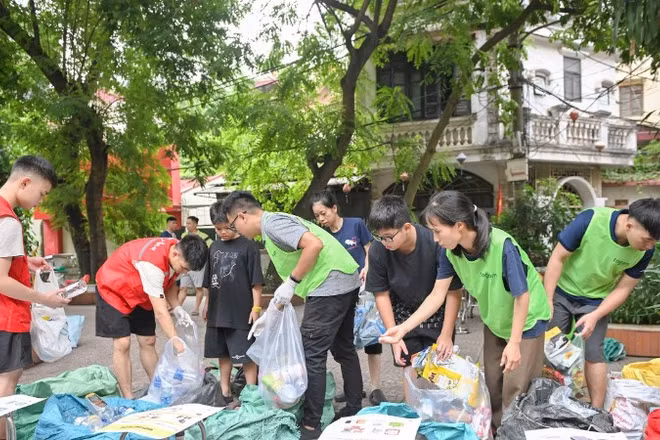 Các thành viên nhóm Tagom ở Hà Nội hướng dẫn người dân cách phân loại rác. (Ảnh THẾ ĐẠI)