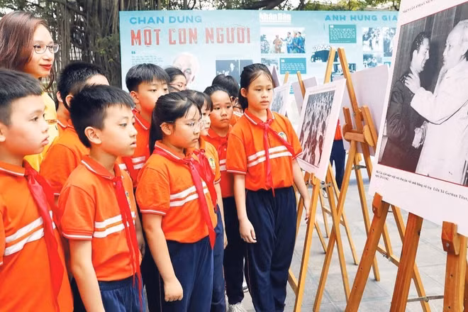Học sinh tham quan triển lãm ảnh “Rạng rỡ tên Người” nhân dịp kỷ niệm 135 năm Ngày sinh Chủ tịch Hồ Chí Minh do Báo Nhân Dân tổ chức. (Ảnh: KHIẾU MINH)