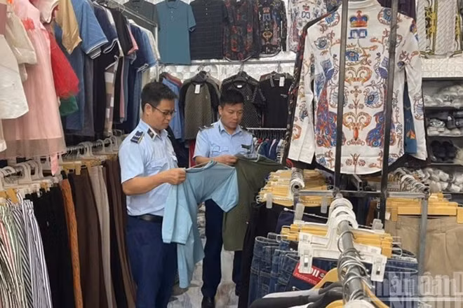 Kiểm tra hàng hóa tại cửa hàng kinh doanh quần áo may sẵn. (Ảnh: THANH SƠN)