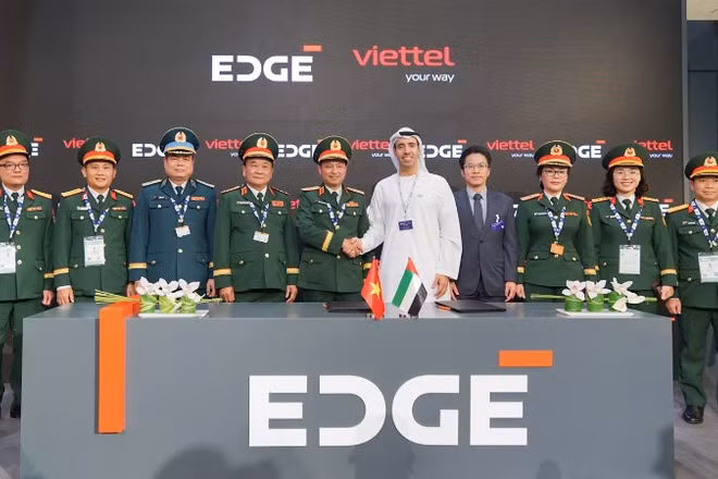 Thiếu tướng Nguyễn Đình Chiến - Phó Tổng Giám đốc Tập đoàn Viettel (thứ 5 từ trái sang) và ông Omar Al Zaabi - Chủ tịch thương mại EDGE bắt tay tại lễ ký dưới sự chứng kiến ​​của Thượng tướng Hoàng Xuân Chiến - Ủy viên Trung ương Đảng, Thứ trưởng Quốc phòng (thứ 4 từ trái sang).