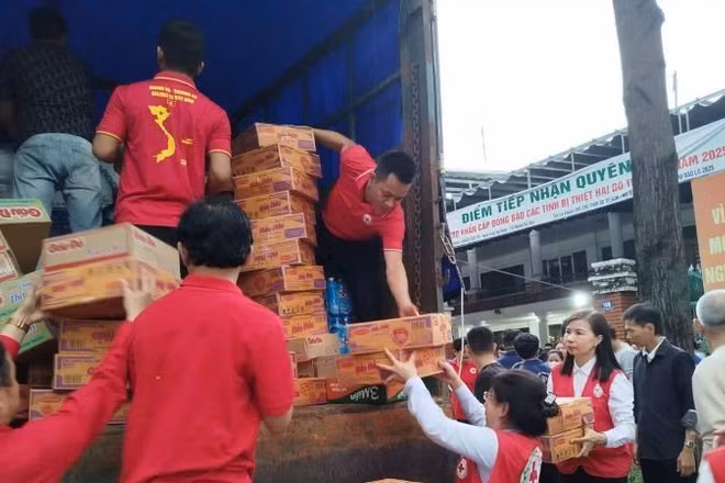 Cán bộ Hội Chữ thập đỏ Thành phố Hồ Chí Minh bốc xếp hàng hóa, thực phẩm lên xe để hỗ trợ các tỉnh bị thiên tai phía bắc. 
