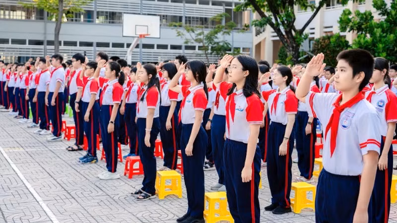 Học sinh Trường trung học cơ sở Nguyễn An Ninh, phường Tam Thắng, Thành phố Hồ Chí Minh chào cờ. 