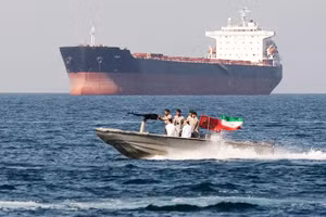 Xuồng vũ trang của Iran hoạt động gần một tàu hàng ở Eo biển Hormuz. Ảnh: AP