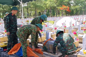Thành viên Đội 584 (Bộ Chỉ huy quân sự tỉnh Quảng Trị) lấy mẫu để giám định ADN ở phần mộ liệt sĩ chưa xác định được thông tin. (Ảnh HIẾU MINH)