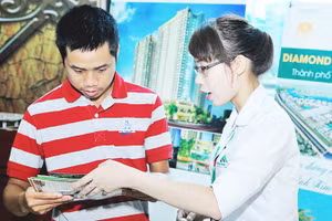 Nhân viên ngân hàng tư vấn người tiêu dùng vay tiền mua nhà. Ảnh: NAM ANH