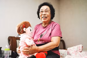 Bà Bang bên cạnh búp bê AI của mình. Ảnh: AFP