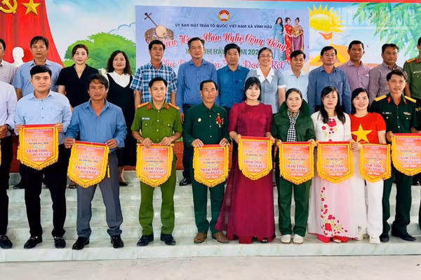 Lãnh đạo tỉnh Cà Mau và Đảng ủy, Ủy ban nhân dân xã Vĩnh Hậu tặng cờ lưu niệm các đơn vị tham gia các hoạt động "Thắm tình đoàn kết" của địa phương năm 2026. (Ảnh: ĐẶNG THẾ VĨNH)