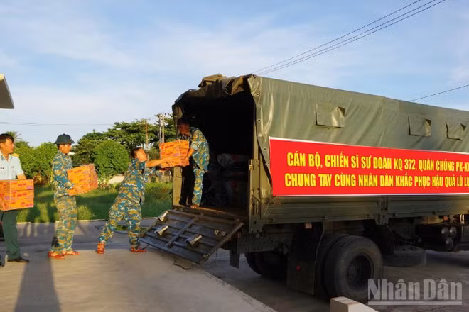Cán bộ, chiến sĩ Sư đoàn Không quân 372 vận chuyển hàng hóa lên xe để gửi đến đồng bào miền bắc bị ảnh hưởng bởi mưa lũ.