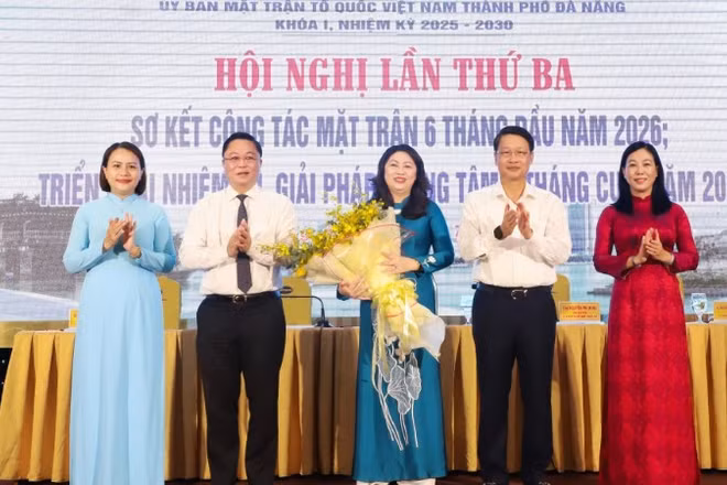 Phó Bí thư Thành ủy Đà Nẵng Ngô Xuân Thắng (thứ 2 bên phải qua) và Chủ tịch Ủy ban Mặt trận Tổ quốc Việt Nam thành phố Đà Nẵng Lê Trí Thanh (thứ 2 bên trái qua) tặng hoa chúc mừng bà Nguyễn Thị Thu Lan.